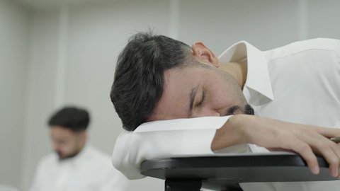 جودة التعليم العالي في المملكة العربية السعودية، صعوبة الاستيقاظ باكرا، السعي للتفوق والنجاح، التعب والاجهاد اثناء حضور المحاضرات اليومية، طالب جامعي عربي خليجي سعودي يرتدي الزي التقليدي نائم على المقعد الدراسي