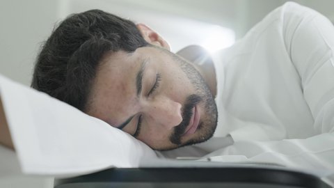 صعوبة الاستيقاظ باكرا، السعي للتفوق والنجاح، التعب والاجهاد اثناء حضور المحاضرات اليومية، جودة التعليم العالي في المملكة العربية السعودية، طالب جامعي عربي خليجي سعودي يرتدي الزي التقليدي نائم على المقعد الدراسي