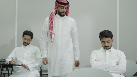 جودة التعليم العالي في المملكة العربية السعودية، صعوبة الاستيقاظ باكرا، السعي للتفوق والنجاح، التعب والاجهاد اثناء حضور المحاضرات اليومية، طالب جامعي عربي خليجي سعودي يرتدي الزي التقليدي نائم على المقعد الدراسي