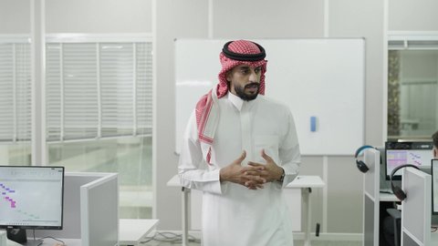 Effective teaching in Saudi Arabia, higher education in universities and colleges, classrooms and lecture halls equipped with the latest technological devices, a Gulf Arab Saudi university professor wearing traditional attire and a ghutrah delivering an educational lecture, the quality of university education in the Kingdom of Saudi Arabia.