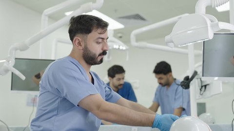 مجموعة من الطلاب الجامعيين بكلية الأسنان يرتدون القفازات يقومون بفحص الأسنان على مجسم، استخدام معدات وأدوات طب الأسنان، الأساليب العلاجية المتبعة للعناية بالفم، معالجة التسوس وتركيب الحشوات