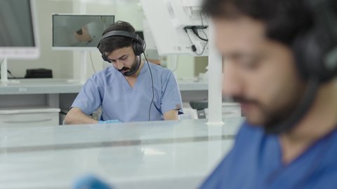 معالجة التسوس وتركيب الحشوات،استخدام معدات وأدوات طب الأسنان، الأساليب العلاجية المتبعة للعناية بالفم، مجموعة من الطلاب الجامعيين بكلية الأسنان يرتدون القفازات يقومون بفحص الأسنان على مجسم