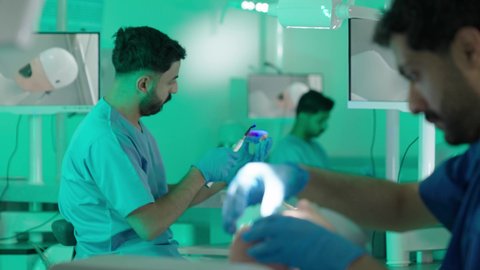 معالجة التسوس وتركيب الحشوات،استخدام معدات وأدوات طب الأسنان، الأساليب العلاجية المتبعة للعناية بالفم،  مجموعة من الطلاب الجامعيين بكلية الأسنان يرتدون القفازات يقومون بفحص الأسنان على مجسم