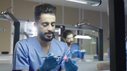 المعدات والادوات اللازمة لإجراء الفحوصات، التعليم الجامعي فى المملكه العربيه السعوديه ، معالجة التسوس وتركيب الحشوات، الأساليب العلاجية المتبعة للعناية بالفم، مجموعة من الطلاب الجامعيين السعوديين بكلية الأسنان يرتدون القفازات يقومون بنحت طاقم أسنان