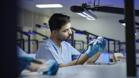 المعدات والادوات اللازمة لإجراء الفحوصات، التعليم الجامعي فى المملكه العربيه السعوديه ، معالجة التسوس وتركيب الحشوات، الأساليب العلاجية المتبعة للعناية بالفم، مجموعة من الطلاب الجامعيين السعوديين بكلية الأسنان يرتدون القفازات يقومون بنحت طاقم أسنان