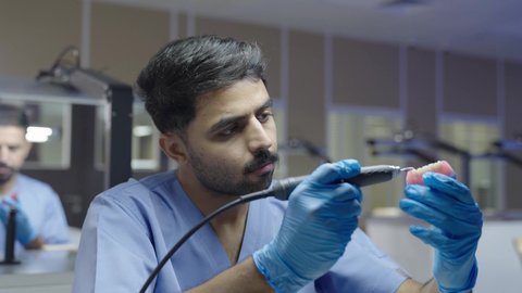 مفهوم التدريب العلمي ،التعليم الجامعي فى المملكه العربيه السعوديه ، معالجة التسوس وتركيب الحشوات،استخدام معدات وأدوات طب الأسنان، مجموعة من الطلاب الجامعيين السعوديين بكلية الأسنان يرتدون القفازات يقومون بنحت طاقم أسنان