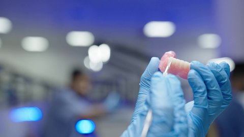 معالجة التسوس وتركيب الحشوات،التعليم الجامعي فى المملكه العربيه السعوديه ، استخدام معدات وأدوات طب الأسنان، الأساليب العلاجية المتبعة للعناية بالفم، مجموعة من الطلاب الجامعيين السعوديين بكلية الأسنان يرتدون القفازات يقومون بنحت طاقم أسنان