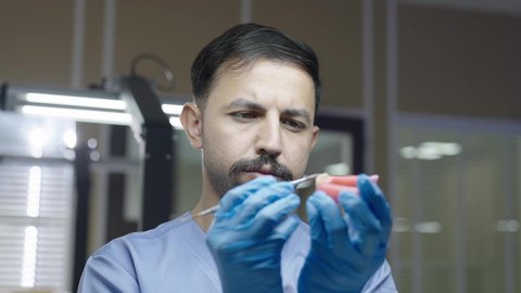 استخدام معدات وأدوات طب الأسنان، التعليم الجامعي فى المملكه العربيه السعوديه ، معالجة التسوس وتركيب الحشوات،الأساليب العلاجية المتبعة للعناية بالفم، مجموعة من الطلاب الجامعيين السعوديين بكلية الأسنان يرتدون القفازات يقومون بنحت طاقم أسنان