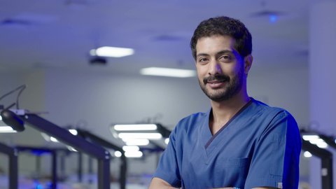 التعليم الجامعي فى المملكه العربيه السعوديه ، النظر الى الكاميرا بايماءات السعاده والثقه بالنفس ، طالب جامعي عربي سعودي بكلية الاسنان يقف بايدي متقاطعه  ، مفهوم العنايه بصحة الفم، التدريب العملي  فى السعودية