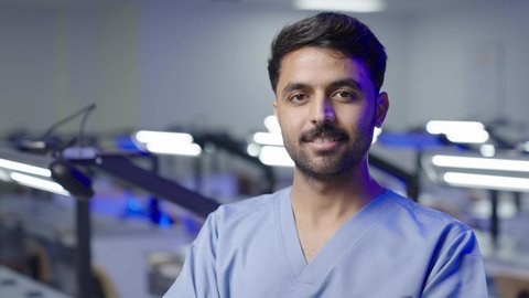 مفهوم العنايه بصحة الفم، التعليم الجامعي فى المملكه العربيه السعوديه ، النظر الى الكاميرا بايماءات السعاده والثقه بالنفس ، طالب جامعي عربي سعودي بكلية الاسنان يقف بايدي متقاطعه  ،  التدريب العملي  فى السعودية