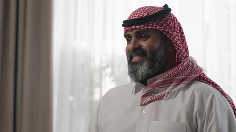 عادات وتقاليد المجتمع السعودي في الأعياد والمناسبات الاسلامية، الاصالة والعراقة والتراث السعودي, عطورات وروائح خليجية مميزة، رجل شايب كبير بالسن عربي خليجي سعودي يرتدي الثوب التقليدي والشماغ يقوم بتبخير نفسه بالمبخرة برفقة ابنه، التبخر والتطيب بخشب العود