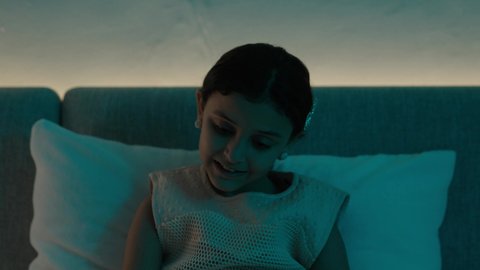 تمضية أوقات الفراغ بالتعلم والتثقف الذاتي, إيماءات الانتباه والتركيز بالمطالعة, تصوير مقرب لفتاة عربية خليجية سعودية تجلس على السرير تقوم بالقراءة بتمعن قبل النوم , مطالعة القصص التصويرية المسلية, تنمية مهارات القراءة للأطفال, الاهتمام بتصفح الكتب المفيدة