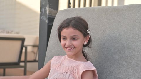  التأرجح على الأرجوحه, الإستمتاع باللعب في يوم مشمس, قضاء وقت ممتع في الخارج، فتاة عربيه سعوديه خليجيه مبتسمة تلعب في المنتزه بتعابير السرور والسعادة 