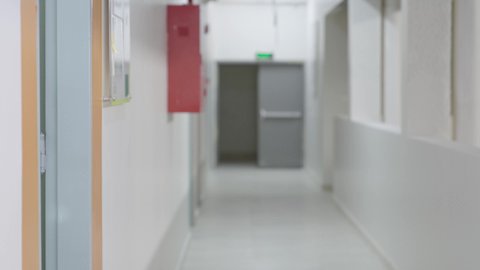 Using the tablet in studying, teamwork and collaboration among colleagues, discussing study materials, a Saudi Gulf Arab student wearing a white thobe and a shemagh, carrying a school bag, walking inside the school with a classmate, the concept of e-learning, using modern technological devices.