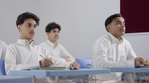 التربية والتعليم بالمناهج المقررة، الانجاز و النجاح في المرحلة التعليمية، تصوير مجموعه لمجموعه من الطلاب العربيون الخليجيون السعودوين يرتدون الثوب الابيض يقومون بالاستماع لشرح الدرس، مفهوم الاجتهاد وطلب التفوق، ايماءات الاندماج و التركيز