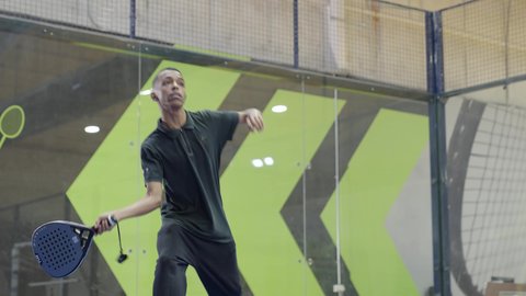 خوض المباريات والبطولات بتحدي وعزيمة، تعابير وإيماءات تدل على الحماس والاندماج بالتمرين، التدرب على إتقان لعبة البادل، القيام بتمرينات رياضة التنس، رياضات شبابية وأنشطة ترفيهية،شاب عربي خليجي سعودي يرتدي ملابس رياضية يلعب مباراة كرة المضرب