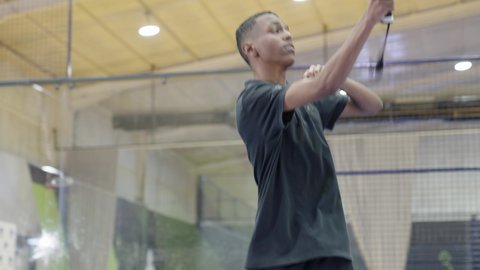 تعابير وإيماءات تدل على الحماس والاندماج بالتمرين، التدرب على إتقان لعبة البادل، خوض المباريات والبطولات بتحدي وعزيمة، القيام بتمرينات رياضة التنس، رياضات شبابية وأنشطة ترفيهية،شاب عربي خليجي سعودي يرتدي ملابس رياضية يلعب مباراة كرة المضرب