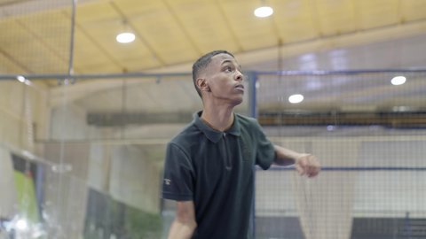 التدرب على إتقان لعبة البادل، خوض المباريات والبطولات بتحدي وعزيمة، القيام بتمرينات رياضة التنس، رياضات شبابية وأنشطة ترفيهية،شاب عربي خليجي سعودي يرتدي ملابس رياضية يلعب مباراة كرة المضرب، تعابير وإيماءات تدل على الحماس والاندماج بالتمرين