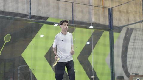 خوض المباريات والبطولات بتحدي وعزيمة، القيام بتمرينات رياضة التنس، رياضات شبابية وأنشطة ترفيهية،شاب عربي خليجي سعودي يرتدي ملابس رياضية يلعب مباراة كرة المضرب، التدرب على إتقان لعبة البادل، تعابير وإيماءات تدل على الحماس والاندماج بالتمرين