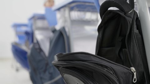 تأدية الواجبات المدرسية، الإستعداد للعام الدراسي الجديد، التعليم في سلطنة عمان، العودة إلى المدارس، مجموعة من الطلاب العربيين الخليجيين العمانيين يرتدون الدشداشة والكمة يجلسون في مقاعدهم ويقومون بحل الواجب