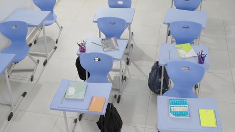 العودة إلى المدارس، تأدية الواجبات المدرسية، الإستعداد للعام الدراسي الجديد، التعليم في سلطنة عمان،  مجموعة من الطلاب العربيين الخليجيين العمانيين يرتدون الدشداشة والكمة يجلسون في مقاعدهم ويقومون بحل الواجب