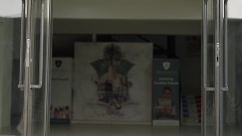 رجل عربي خليجي عماني يرتدي الدشداشة والكمة يقوم بمصافحة ابنه ليدخل الى بهو المدرسه, ايماءات السعاده والمرح,مدارس أكاديميه في سلطنة عمان ، الإستعداد للفصل الدراسي الجديد