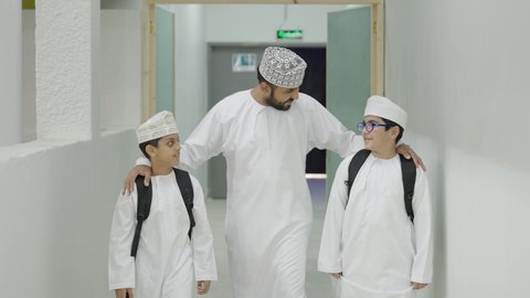 طلاب عرب عمانيون خليجيون يخرجون الى بهو المدرسه مع معلمهم،  ايماءات السعاده والمرح, الإستعداد للفصل الدراسي الجديد,وقت اللعب والترفيه,  مدارس أكاديميه في سلطنة عمان