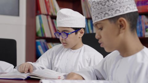 مفهوم التعليم وحب الاستطلاع ،قضاء وقت ممتع ، مجموعة من طلاب عربية عمانية خليجية في المكتبة المدرسية، الاستمتاع بقراءة الكتب المدرسية، تأدية الواجبات المدرسية، التعليم في سلطنة عمان