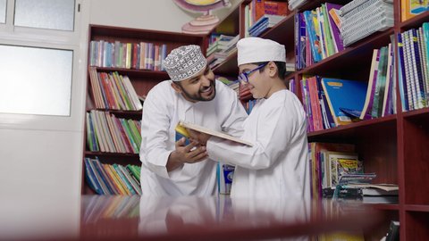 المشاركة الفعالة للطلاب مع المدرسين، الاستمتاع بقراءة الكتب المدرسية ، معلم عربي خليجي عماني يرتدي الدشداشة والكمة يقوم بمناقشة الكتاب مع طلابه، جودة التعليم في سلطنة عمان ، مفهوم التعليم والثقافة ، حوارات ودية بين الاستاذ والطلاب