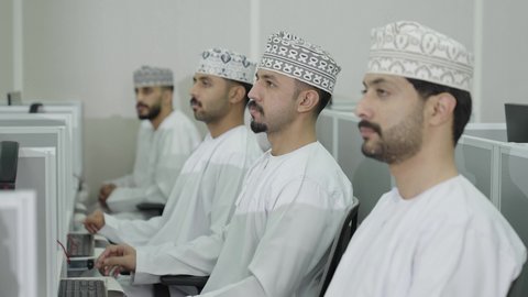 المشاركة الفعالة في الفصل،تصوير لطالب عربي خليجي عماني  يرتدي الدشداشة و الكمة يقوم برفع يده بايماءات طلب الاذن للاجابة على السؤال، مجموعة من الطلاب يقومون بالاستماع الى المحاضرة، جودة التعليم في الجامعات