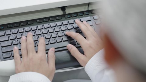 البحث والمطالعة وتصفح التطبيقات الالكترونية، متابعة الدرجات من خلال الحاسب المحمول،  تصوير مقرب ليد طالب جامعى عربي خليجي عماني يقوم بالنقر على لوحه المفاتيح