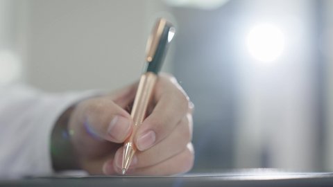 الاجتهاد في الدراسة لتحقيق النجاح والتميز الأكاديمي, تصوير مقرب ليد طالب عربي خليجي عماني يقوم بحل أسئلة الامتحان, اهداف التربية و التعليم, التعليم في سلطنه عمان