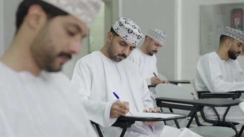 تعابير التمعن والتركيز، السعي نحو تحقيق النجاح والتميز الدراسي, تصوير مقرب لمجموعة من الطلاب العمانيين  يقومون بحل أسئلة الامتحان, اهداف التربية و التعليم, التعليم في سلطنه عمان
