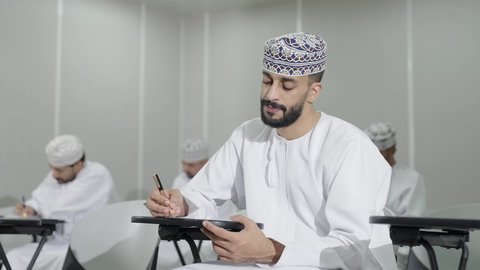 السعي نحو التفوق من خلال الدراسة, تصوير مقرب لمجموعة من الطلاب العمانيين  يقومون بحل أسئلة الامتحان, اهداف التربية و التعليم, التعليم في سلطنه عمان، تعابير التمعن والتركيز