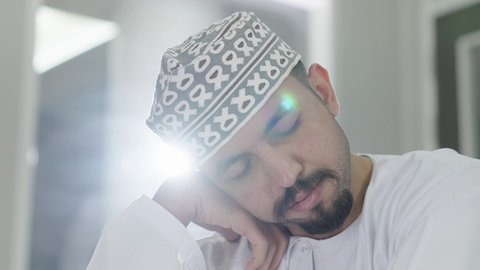 الراحة والنوم الكافي أساس تعزيز الصحة العقلية والجسدية للطلاب، التعب والاجهاد أثناء الدراسة، تصوير مقرب لطالب عربي خليجي عماني يرتدي الدشداشة و الكمه ياخذ قيلولة