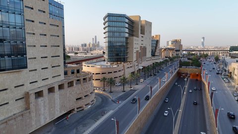The economic and urban renaissance of the capital's skyline, the movement of transportation and communication means on the streets and main roads in the Kingdom of Saudi Arabia, aerial drone photography of organized traffic movement of cars, the growth and development of infrastructure