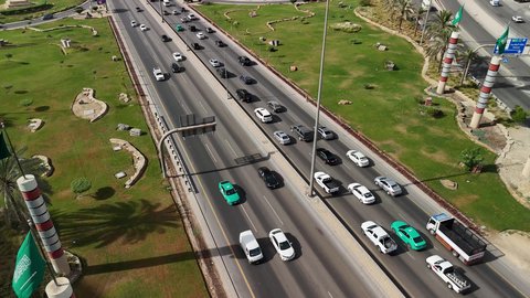 التقدم والتطور العمراني على الطراز الحديث والمتطور، النهضة الاقتصادية والعمرانية لأفق العاصمة, حركة وسائل النقل والمواصلات في الشوارع والطرقات الرئيسية في المملكة العربية السعودية، تصوير درون جوي للحركة المرورية المنظمة للسيارات، نمو وتطور البنية التحتية