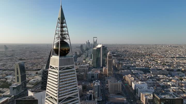 مبنى برج الفيصلية في حي العليا في مدينة الرياض، التقدم العمراني في العاصمة، الفن الهندسي المعماري للأبراج و ناطحات السحاب، تصوير درون جوي لمعلم سياحي مشهور في المملكة العربية السعودية، النهضة الاقتصادية والعمرانية