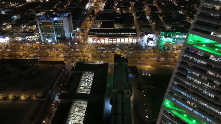 Saudi Arabia's economic and urban renaissance, aerial drone footage of the Al Faisaliah Tower in Riyadh, the advanced architectural style of the Olaya Towers, King Fahd Road in the Kingdom, celebrating Saudi National Day on September 23, lighting skyscrapers, tourist facilities, and hotels in green