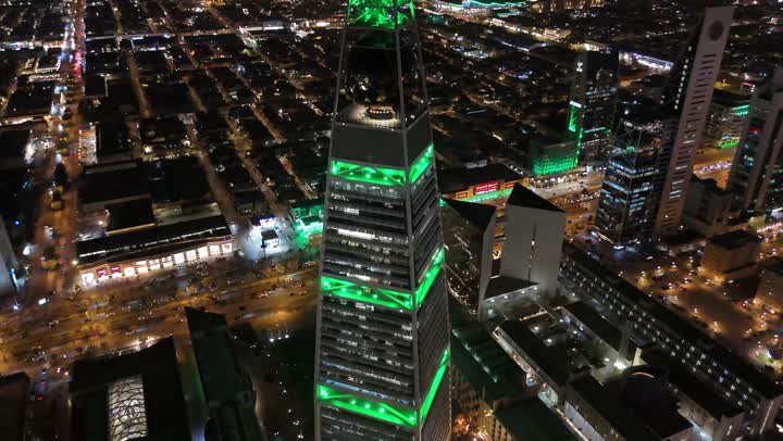 طريق الملك فهد في المملكة، الاحتفال باليوم الوطني السعودي في 23 سبتمبر، إنارة ناطحات السحاب والمنشآت والفنادق السياحية باللون الأخضر، النهضة الاقتصادية والعمرانية السعودية، تصوير درون جوي لبرج الفيصلية في الرياض، الفن الهندسي المعماري على الطراز المتطور لأبراج العليا