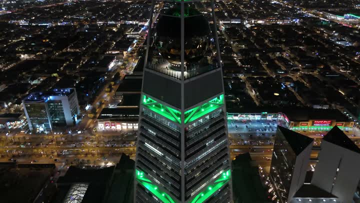 طريق الملك فهد في المملكة، الاحتفال باليوم الوطني السعودي في 23 سبتمبر، إنارة ناطحات السحاب والمنشآت والفنادق السياحية باللون الأخضر، النهضة الاقتصادية والعمرانية السعودية، تصوير درون جوي لبرج الفيصلية في الرياض، الفن الهندسي المعماري على الطراز المتطور لأبراج العليا