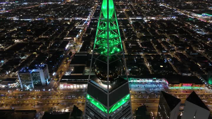 طريق الملك فهد في المملكة، الاحتفال باليوم الوطني السعودي في 23 سبتمبر، إنارة ناطحات السحاب والمنشآت والفنادق السياحية باللون الأخضر، النهضة الاقتصادية والعمرانية السعودية، تصوير درون جوي لبرج الفيصلية في الرياض، الفن الهندسي المعماري على الطراز المتطور لأبراج العليا