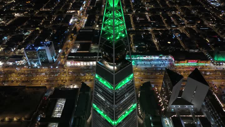 طريق الملك فهد في المملكة، الاحتفال باليوم الوطني السعودي في 23 سبتمبر، إنارة ناطحات السحاب والمنشآت والفنادق السياحية باللون الأخضر، النهضة الاقتصادية والعمرانية السعودية، تصوير درون جوي لبرج الفيصلية في الرياض، الفن الهندسي المعماري على الطراز المتطور لأبراج العليا