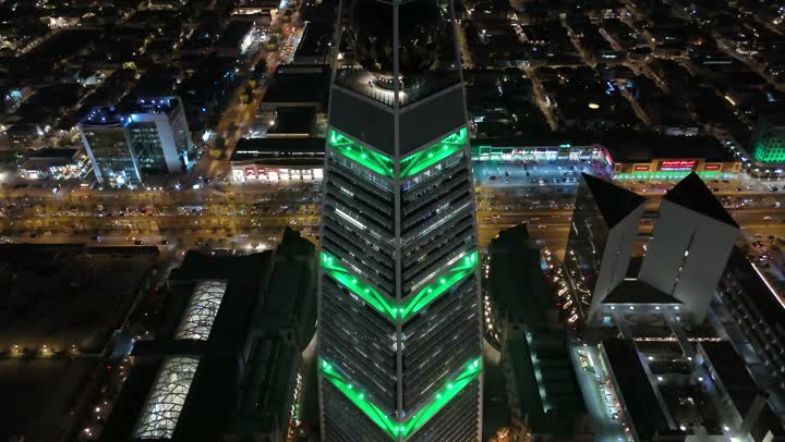 طريق الملك فهد في المملكة، الاحتفال باليوم الوطني السعودي في 23 سبتمبر، إنارة ناطحات السحاب والمنشآت والفنادق السياحية باللون الأخضر، النهضة الاقتصادية والعمرانية السعودية، تصوير درون جوي لبرج الفيصلية في الرياض، الفن الهندسي المعماري على الطراز المتطور لأبراج العليا