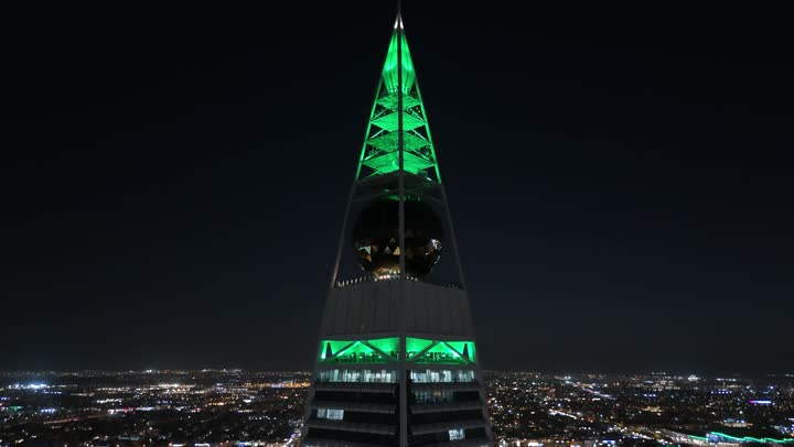 إنارة ناطحات السحاب والمنشآت والفنادق السياحية باللون الأخضر في اليوم الوطني السعودي في 23 سبتمبر, النهضة الاقتصادية والعمرانية السعودية، تصوير درون جوي لبرج الفيصلية في الرياض، الفن الهندسي المعماري على الطراز المتطور لأبراج العليا, طريق الملك فهد في المملكة