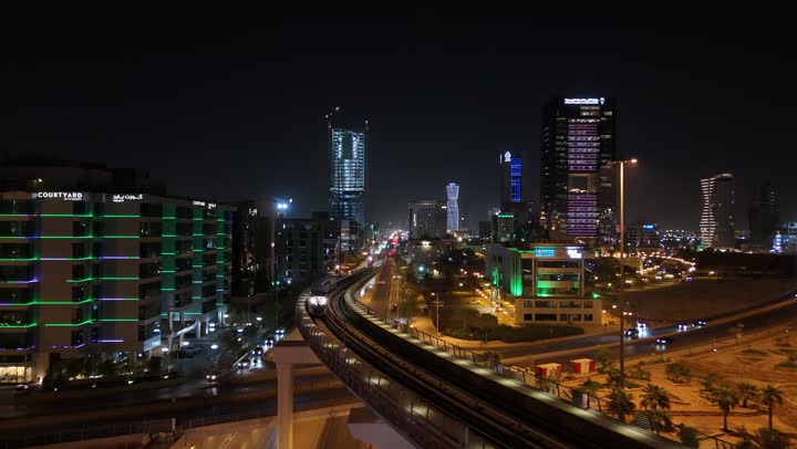 Towers and skyscrapers in the Kingdom of Saudi Arabia, urban growth and progress, the architectural art of modern commercial and residential buildings and facilities, traffic in the capital's illuminated streets at night, and attention to infrastructure in the city of Riyadh.