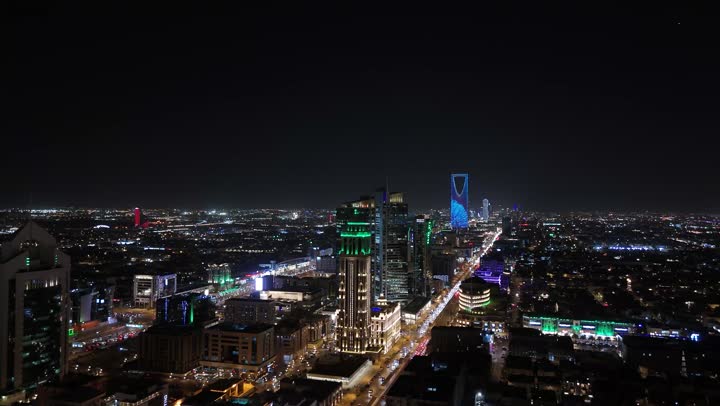 الاهتمام بالبنية التحتية في مدينة الرياض، الفن الهندسي المعماري للابراج وناطحات السحاب في المملكة العربية السعودية، الشوارع المعبدة والطرقات، المنشأت التجارية والسكنية والمباني على الطراز الحديث، تصوير درون جوي لحركة مرور السيارات في شوارع العاصمة المضيئة ليلا