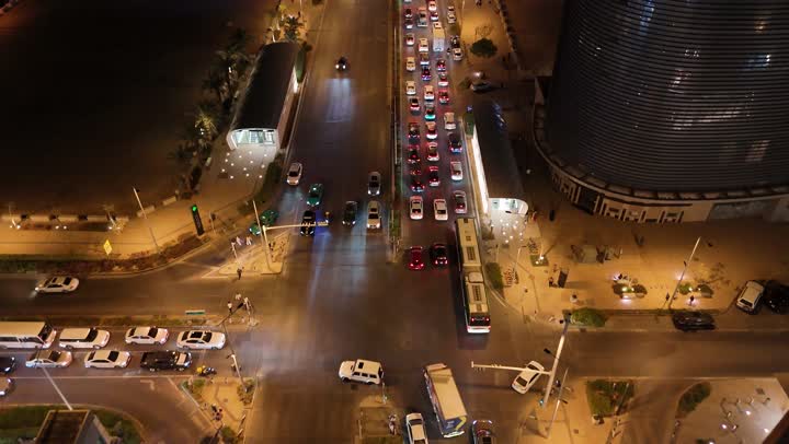 الاهتمام بالبنية التحتية في مدينة الرياض، الفن الهندسي المعماري للابراج وناطحات السحاب في المملكة العربية السعودية، الشوارع المعبدة والطرقات، المنشأت التجارية والسكنية والمباني على الطراز الحديث، تصوير درون جوي لحركة مرور السيارات في شوارع العاصمة المضيئة ليلا