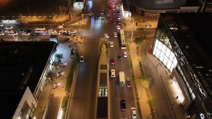 Commercial and residential facilities and modern buildings, aerial drone footage of traffic in the capital's illuminated streets at night, attention to infrastructure in Riyadh, the architectural art of towers and skyscrapers in Saudi Arabia, urban growth and progress