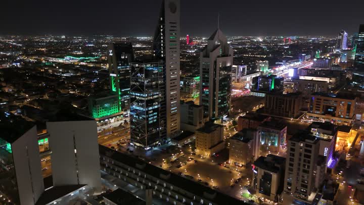 الشوارع المعبدة والطرقات، المنشأت التجارية والسكنية والمباني على الطراز الحديث، تصوير درون جوي لحركة مرور السيارات في شوارع العاصمة المضيئة ليلا، الاهتمام بالبنية التحتية في مدينة الرياض، الفن الهندسي المعماري للابراج وناطحات السحاب في المملكة العربية السعودية